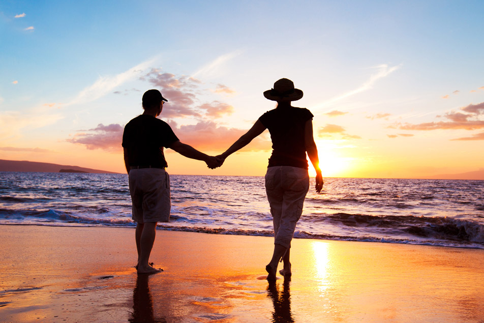 senior couple enjoying beautiful sunset at the beach. Their confidential email will never be compromised.